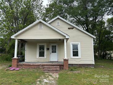 Charming single-story home with a covered front porch and a well-maintained lawn at 110 E Church St, Dallas, NC 28034