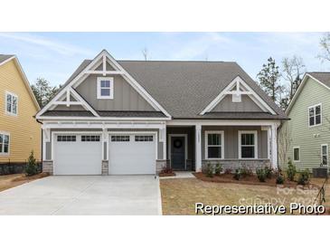 Charming home with a two-car garage, stone accents, and inviting front porch at 13279 Arnold Palmer Cir # 867, Lancaster, SC 29720