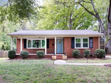 Charming brick home with a well-maintained lawn, blue door and inviting curb appeal at 1408 Wicker Dr, Charlotte, NC 28210