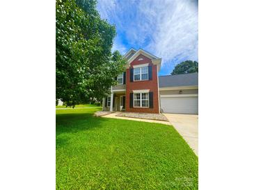 Charming two-story home with a well-manicured lawn and a combination brick and siding exterior at 15003 Jerpoint Abby Dr, Charlotte, NC 28273