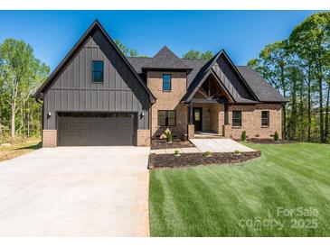 Beautiful two-story home with brick and gray siding, complemented by a well-manicured lawn and a wide driveway at 2008 Plain Field Dr, Bessemer City, NC 28016