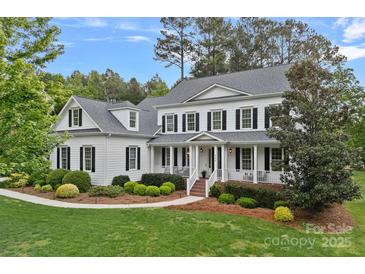 Charming white two-story home with black shutters, a welcoming porch, and manicured landscaping at 208 Grasshopper Cir, Mooresville, NC 28117