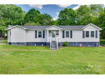 Charming single-story home featuring a well-maintained lawn, dark shutters, and a welcoming front entrance at 220 Tomberlin Rd, Mount Holly, NC 28120