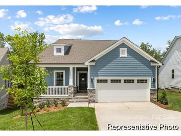 Attractive blue house with a two-car garage, a cozy front porch, and well-maintained landscaping at 24558 Blue Heron Cir # 402, Lancaster, SC 29720