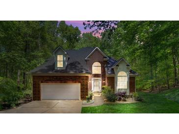 Charming brick home featuring a two-car garage, arched windows and manicured landscaping at 4516 Stryker Dr, Matthews, NC 28104