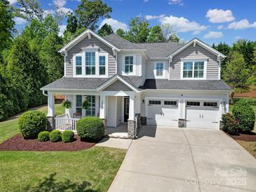 Charming two-story home featuring a welcoming front porch and three-car garage with great curb appeal at 5025 Willing Ct, Fort Mill, SC 29707