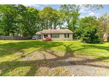 Charming single-story home with lush lawn, mature trees, and a classic brick facade at 627 Gray Dr, Charlotte, NC 28213
