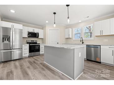 Modern kitchen featuring stainless steel appliances, white cabinets, and a center island with a light gray finish at 6525 Kershaw Camden Hwy, Heath Springs, SC 29058