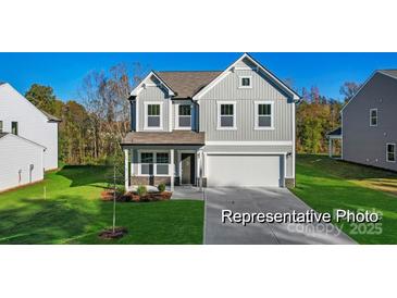Charming two-story home featuring a manicured lawn and a classic gray facade at 9913 Jack Nicklaus Dr # 908, Lancaster, SC 29720