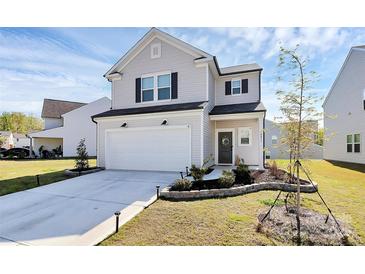 Charming two-story home featuring a well-manicured lawn, attached garage, and welcoming front entrance at 10031 Travis Floyd Ln, Charlotte, NC 28214