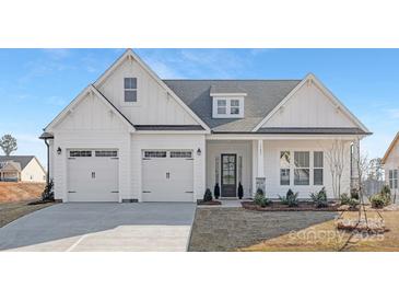 Charming two-story home with a three-car garage, stylish front door, and a well-manicured lawn at 13097 Arnold Palmer Cir # 844, Lancaster, SC 29720