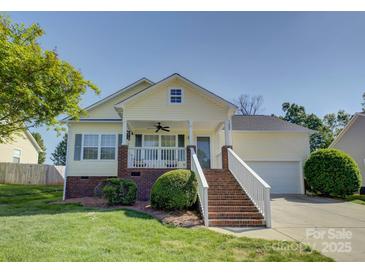 Charming yellow home with a welcoming front porch and well-manicured lawn at 1488 Meadow Glen Ln, Rock Hill, SC 29730