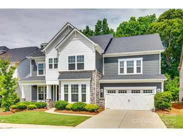 Charming two-story home with a manicured lawn and a two-car garage, showcasing its appealing curb appeal at 15312 Ravenall Dr, Huntersville, NC 28078