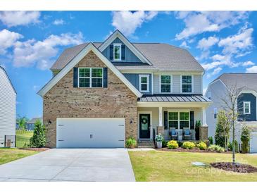 Charming two-story home with a well-manicured lawn, brick accents, a two-car garage and welcoming front porch at 17231 Rider Wood Ln, Charlotte, NC 28278