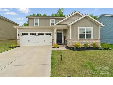Charming two-story home featuring a two-car garage, tidy landscaping, and inviting brick-accented facade at 179 Bezelle Ave # 34, York, SC 29745