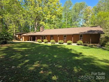 Charming ranch home featuring a long, covered porch and beautiful, mature trees at 1855 7Th St, Salisbury, NC 28144