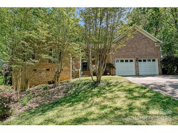 Charming brick home with a two-car garage and a well-maintained lawn with mature trees at 9600 Lockhorn Ct, Mint Hill, NC 28227