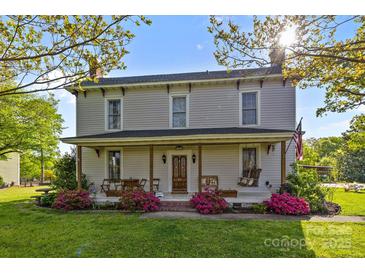 Charming two-story home with a inviting front porch and manicured landscaping at 1321 South Point Rd, Belmont, NC 28012
