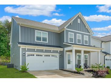 Charming two-story home featuring a two-car garage, covered porch and manicured lawn in a Gathering-friendly neighborhood at 1390 Cedardale Ln, Denver, NC 28037