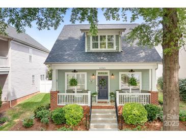 Charming home featuring a welcoming front porch, landscaped yard, and classic architectural details at 14541 Holly Springs Dr, Huntersville, NC 28078