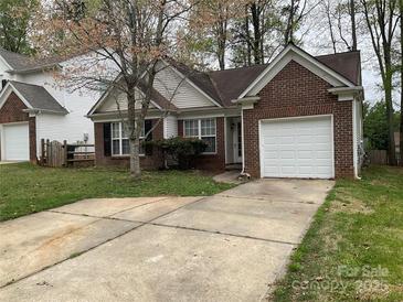 Charming brick home with a single-car garage and well-maintained lawn at 1507 Rumstone Ln, Charlotte, NC 28262