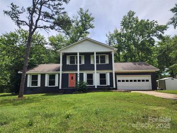 Inviting home boasts traditional charm, a two-car garage and a front yard lush with mature trees at 1620 Matthews Dr, Rock Hill, SC 29732
