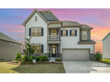 Charming two-story home with white siding, a two-car garage, and manicured landscaping at 17502 Snug Harbor Rd, Charlotte, NC 28278