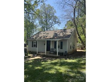 Charming single-story home with a covered front porch and a cozy, inviting feel on a sunny day at 1849 Brownstone St, Charlotte, NC 28216