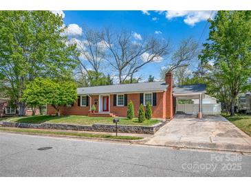 Charming brick home with well-manicured lawn, red front door, and covered carport at 218 N Bost St, Statesville, NC 28677