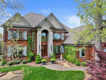 Stately red brick home with lush landscaping, a fountain, and charming architectural details at 4465 3Rd Nw St, Hickory, NC 28601