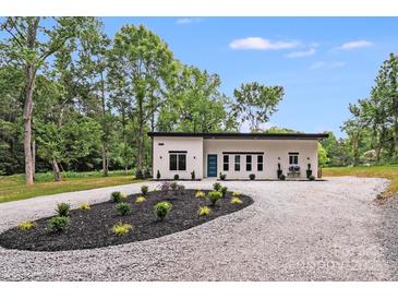 Modern home featuring a gravel driveway and minimalist landscaping at 6907 Lancaster Hwy, Waxhaw, NC 28173