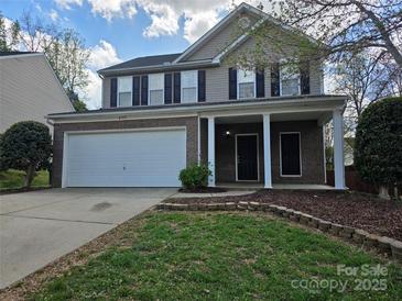 Charming two-story home featuring a brick facade, two-car garage, and inviting front porch at 8323 Carolina Laurel Ct, Charlotte, NC 28215