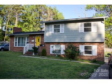 Charming brick home with a bright yellow door and well-maintained lawn at 920 Squirrel Hill Rd, Charlotte, NC 28213