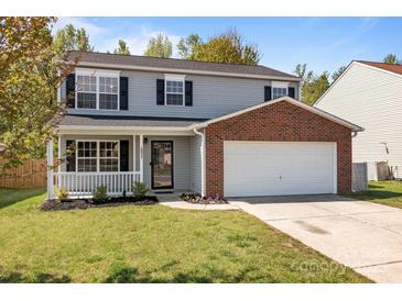 Charming two-story home with gray siding, brick accents, a covered porch, and a two-car garage at 10937 Dry Stone Dr, Huntersville, NC 28078