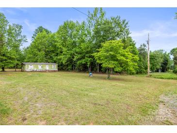 Quaint one-story home with a green lawn and ample privacy provided by mature trees at 1317 Requa Rd, Cherryville, NC 28021