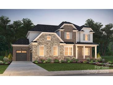 Charming two-story home showcasing a blend of stone and brick, complemented by a well-manicured lawn and inviting curb appeal at 14105 White Gardens Ln # 5, Huntersville, NC 28078