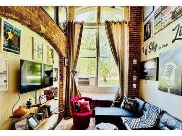 Inviting living room featuring exposed brick, large window, and stylish decor at 201 S Hoskins Rd # 132, Charlotte, NC 28208