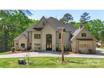 Stunning two-story stucco home featuring a spacious front yard and well-manicured landscaping at 220 Palm Cove Way, York, SC 29745
