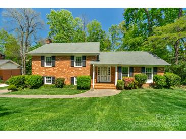 Charming brick home featuring a well-manicured lawn and lush landscaping, creating an inviting curb appeal at 2815 Burnt Mill Rd, Charlotte, NC 28210