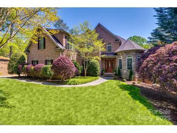 Charming brick home featuring a lush green lawn, mature landscaping, and a welcoming front entrance at 364 Stone Cliff Ln, Clover, SC 29710