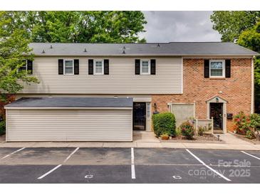 Charming townhome with brick and siding exterior, black shutters, and parking spaces at 5901 Quail Hollow Rd # G, Charlotte, NC 28210