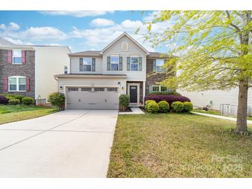 Charming two-story home featuring stone accents, a well-maintained lawn, and a two-car garage at 6702 Carradale Way, Charlotte, NC 28278