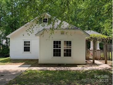 Charming home featuring a bright exterior, traditional windows, and an inviting pergola entrance at 8332 Highlander Ct, Charlotte, NC 28269