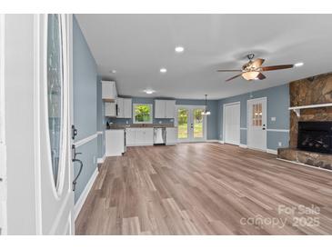 Open-concept living room features a stone fireplace and ample natural light at 1195 Ralph B Keener Rd, Lincolnton, NC 28092