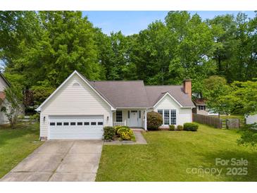 Charming single-story home with a manicured lawn, a two-car garage, and inviting front porch at 13324 Kintyre Ct, Matthews, NC 28105