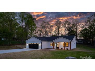 Charming one-story home with a black garage door, craftsman columns, and lush green lawn at 2045 Cordia Cir, Newton, NC 28658