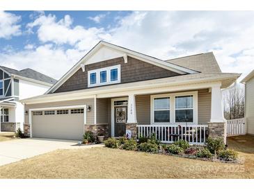 Charming home with a two-car garage, stone accents, covered porch, and beautifully landscaped front yard at 3100 Cheyney Park Dr, Charlotte, NC 28269