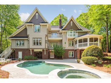 Stunning rear exterior showcasing a sparkling pool, balconies, and a charming screened-in porch at 3201 Oak Brook Dr, Waxhaw, NC 28173