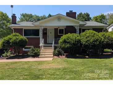 Charming brick home featuring a covered front porch with decorative white columns and landscaped front yard at 351 Glenwood Dr, Mooresville, NC 28115