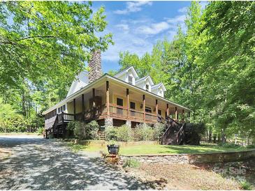 Charming two-story home featuring a spacious porch, stone chimney, and lush landscaping at 729 Lochaven Rd, Waxhaw, NC 28173